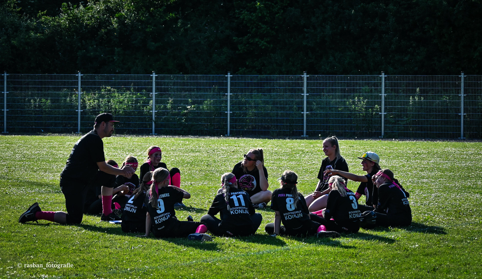 Youth baseball coach with players during a practice session