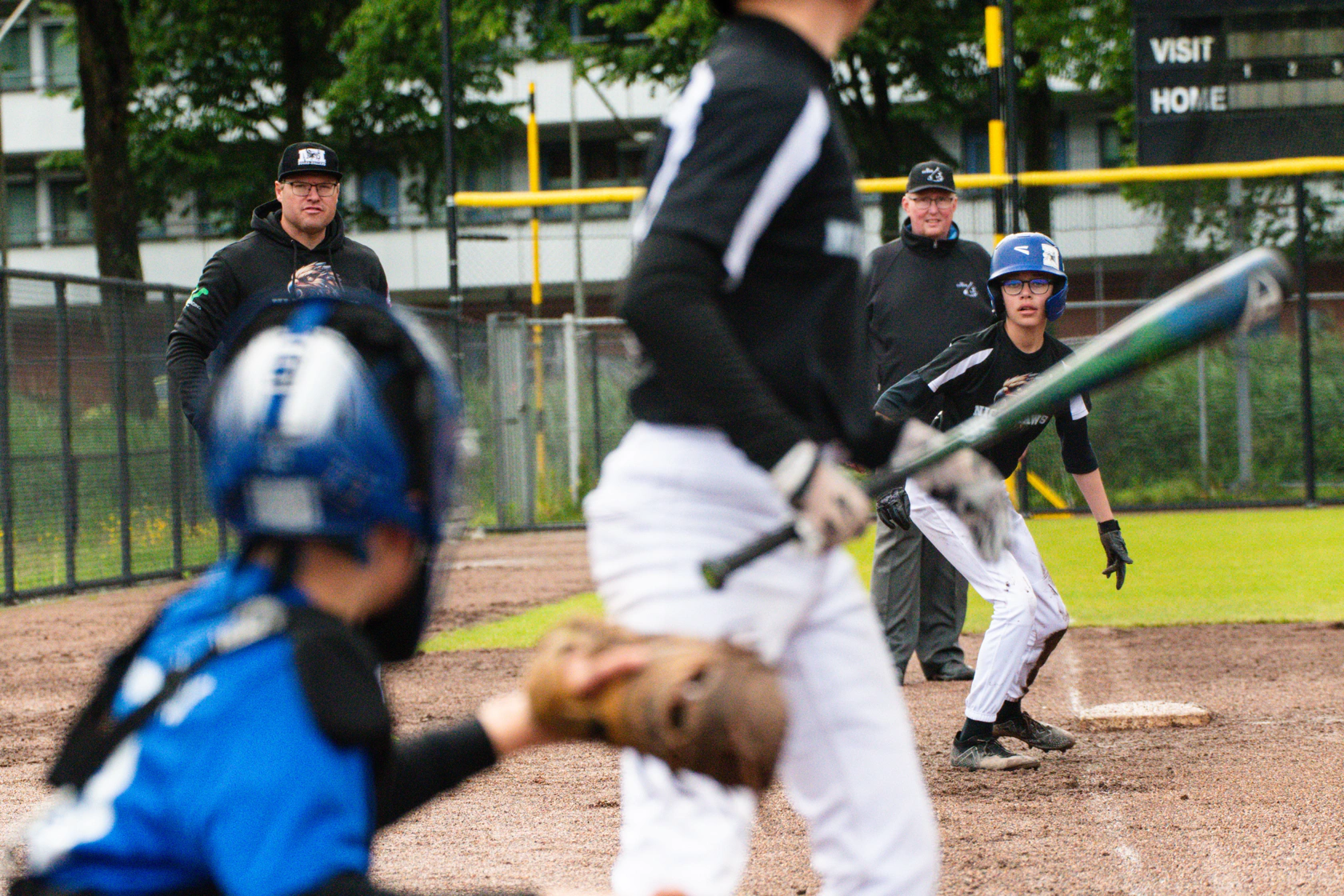Little League team huddle with coach on a baseball field